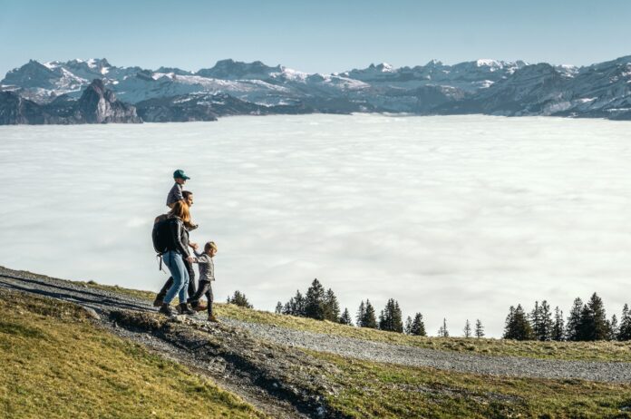 Familie mit zwei Kindern wandert auf der Rigi über dem Nebelmeer Familie mit zwei Kindern wandert auf der Rigi über dem Nebelmeer