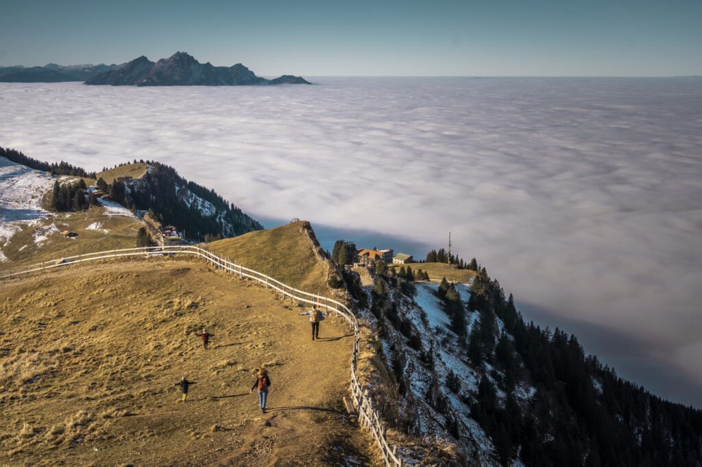Wanderweg auf dem Rigi-Grat im Herbst, darunter ein dichtes Nebelmeer
