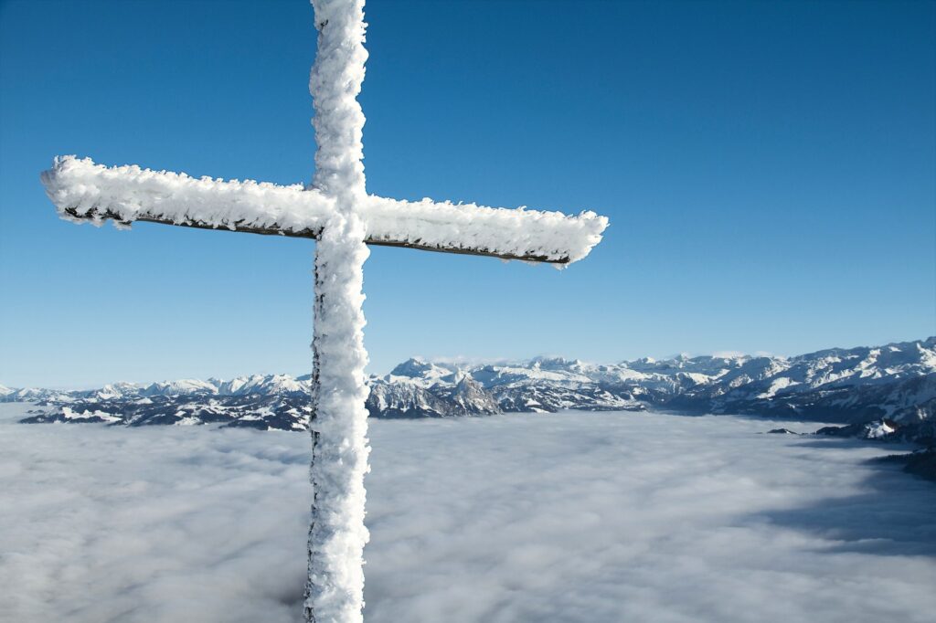 Vereistes Gipfelkreuz auf der Rigi Kulm über dem Nebelmeer mit Alpenpanorama
