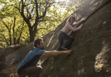 Bouldern mit Kindern: erster Hallenbesuch und Spiele Kind bouldert mit erwachsener Begleitung in Chironico